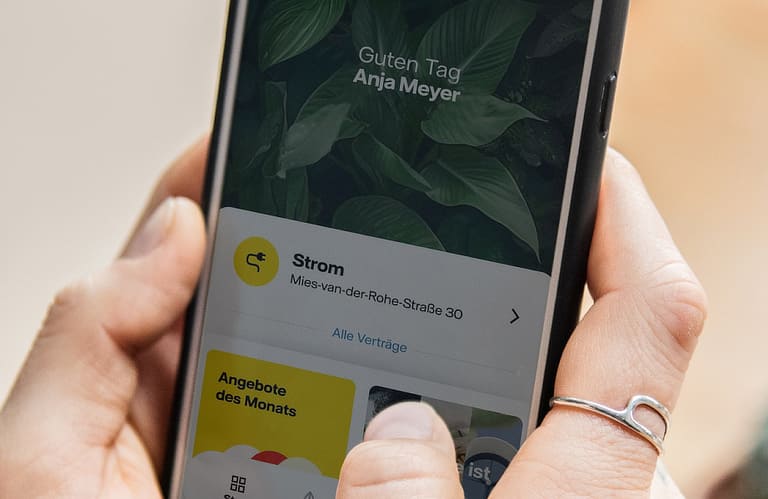 Hand hält Smartphone. Auf dem Bildschirm ist die geöffnete Vattenfall-App zu erkennen.